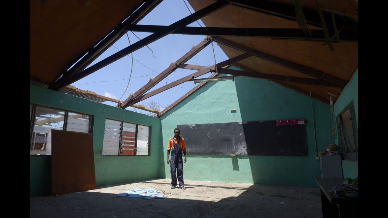 A man stands under the damaged rooftop of a school in Vanuatu's capital, Port Vila, on March 18.