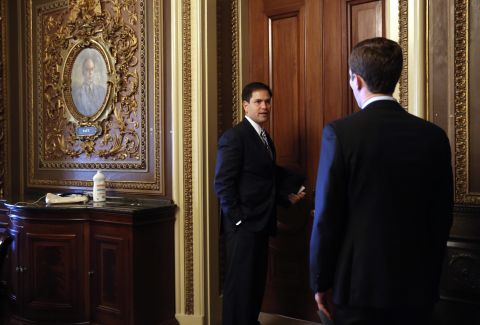 Rubio speaks to an aide on Capitol Hill as he arrives for the weekly Senate Republican Policy Committee luncheon in September 2013.