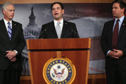Rubio, center, speaks to members of the media as Sen. Ron Johnson, left, and Rep. Ron DeSantis listen during a news conference on Capitol Hill in October 2013.