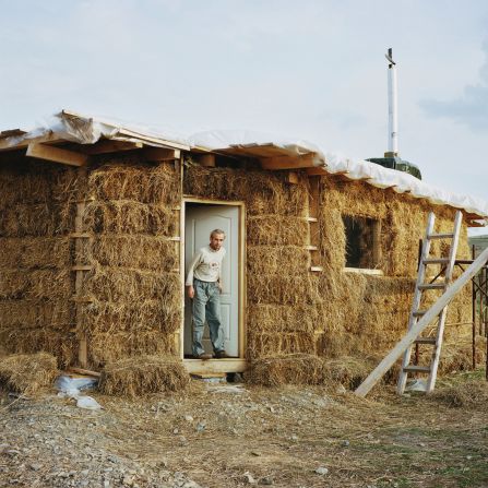 A man peers out from a house made of straw near the town of Zlatna in the Apuseni Mountains, Romania. <br /><br />Bruy visited five different countries -- France, Spain, Switzerland, Romania and Wales -- in carrying out his project.