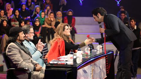 Singer Arash Barez gives a flower to a judge on International Women's Day.