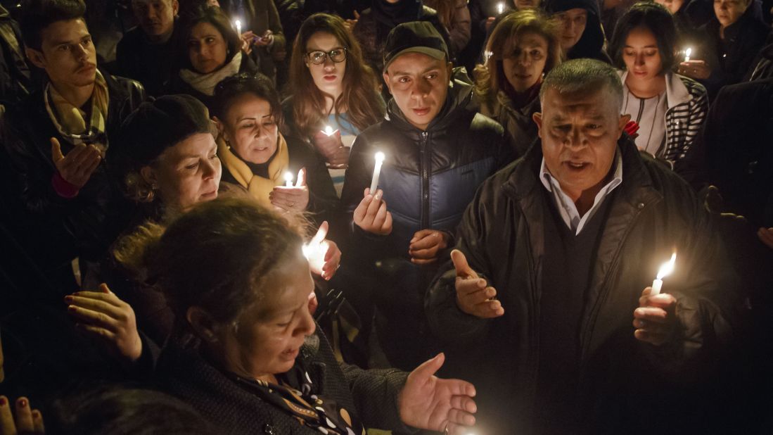 People pray at the entrance gate of the Bardo Museum in Tunis, Tunisia, on Wednesday, March 18. Earlier in the day, at least 23 people were killed -- most of them tourists -- when gunmen opened fire in the museum.