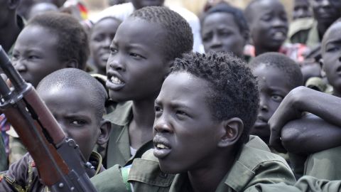 Children sit with their rifles at a ceremony taking place in South Sudan on the issue of the disarmament, demobilization and reintegration of child soldiers. The process was overseen by UNICEF and partners in February 2015.