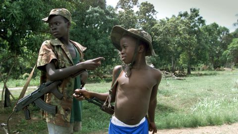 Two children enrolled with Sierra Leone troops battling rebels of the Revolutionary United Front get ready to fight east of the capital of Freetown in May 2000.