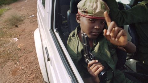 A child with a gun sits in a car with Rwandan Patriotic Front partisans patrolling the streets of Kigali, Rwanda, in June 1994.