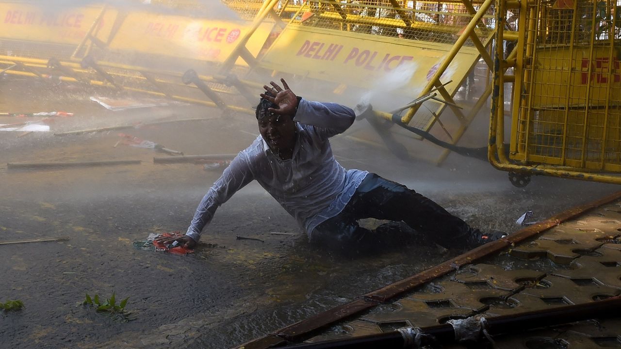 A protester falls after police fired a water cannon during a demonstration in the Indian capital of New Delhi on Monday, March 15. People were rallying against Prime Minister Narenda Modi's land reforms, which they said would harm the country's millions of farmers.
