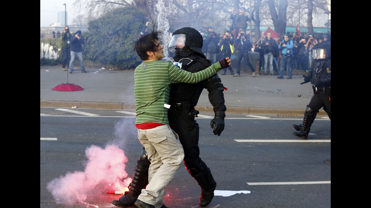 A police officer in Frankfurt, Germany, stops an anti-austerity protester on Wednesday, March 18, before the official opening of the European Central Bank's new headquarters. <a href="http://www.cnn.com/2015/03/18/europe/germany-european-central-bank-protest/index.html" target="_blank">The protest movement, dubbed "Blockupy,"</a> comes amid criticism of austerity measures from the Greek finance minister, who said his country is suffering under the ECB's policies.