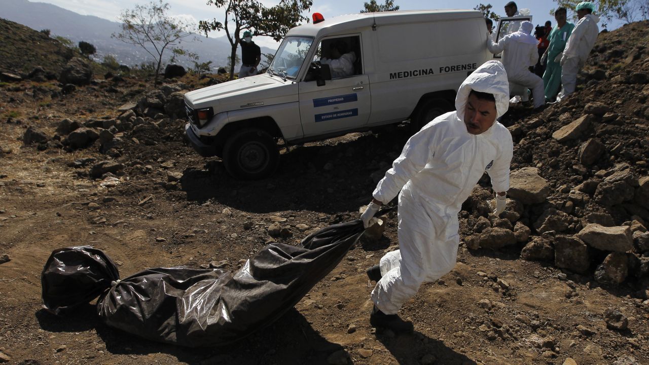 A morgue worker drags an unidentified body toward a grave in Tegucigalpa, Honduras, on Saturday, March 14. Local media said the 49 people buried on Saturday were people who were not claimed from the city morgue and who were mostly killed in drug-related incidents and violence.