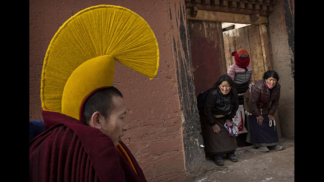 Devotees bow to a passing monk on his way to take part in a special prayer during the Monlam rituals on March 5, 2015. 