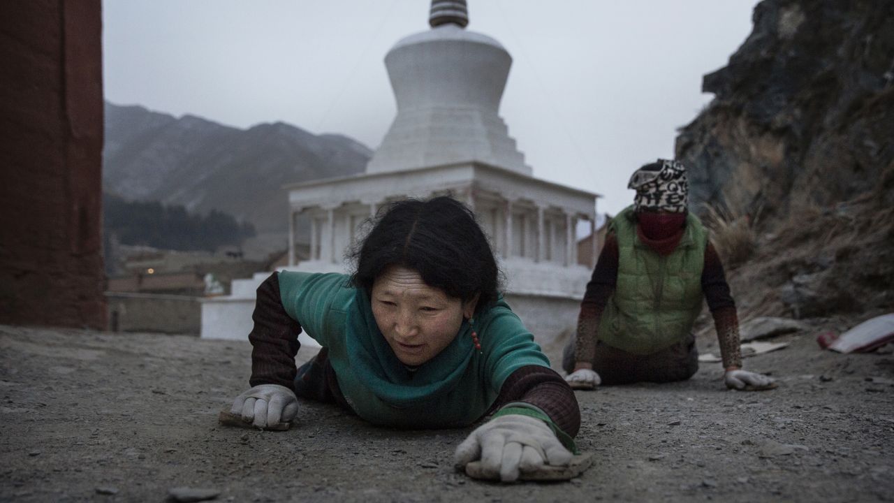 A Tibetan Buddhist prostrates herself on the ground during a pilgrimage for Monlam on March 3, 2015 at Labrang Monastery.