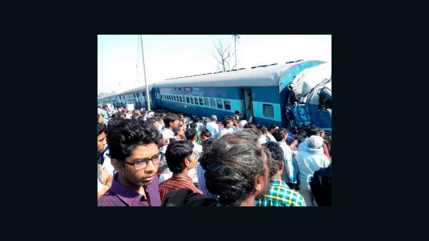 A crowd watches as emergency workers help victims of a passenger train derailment in India's Uttar Pradesh state on Friday.