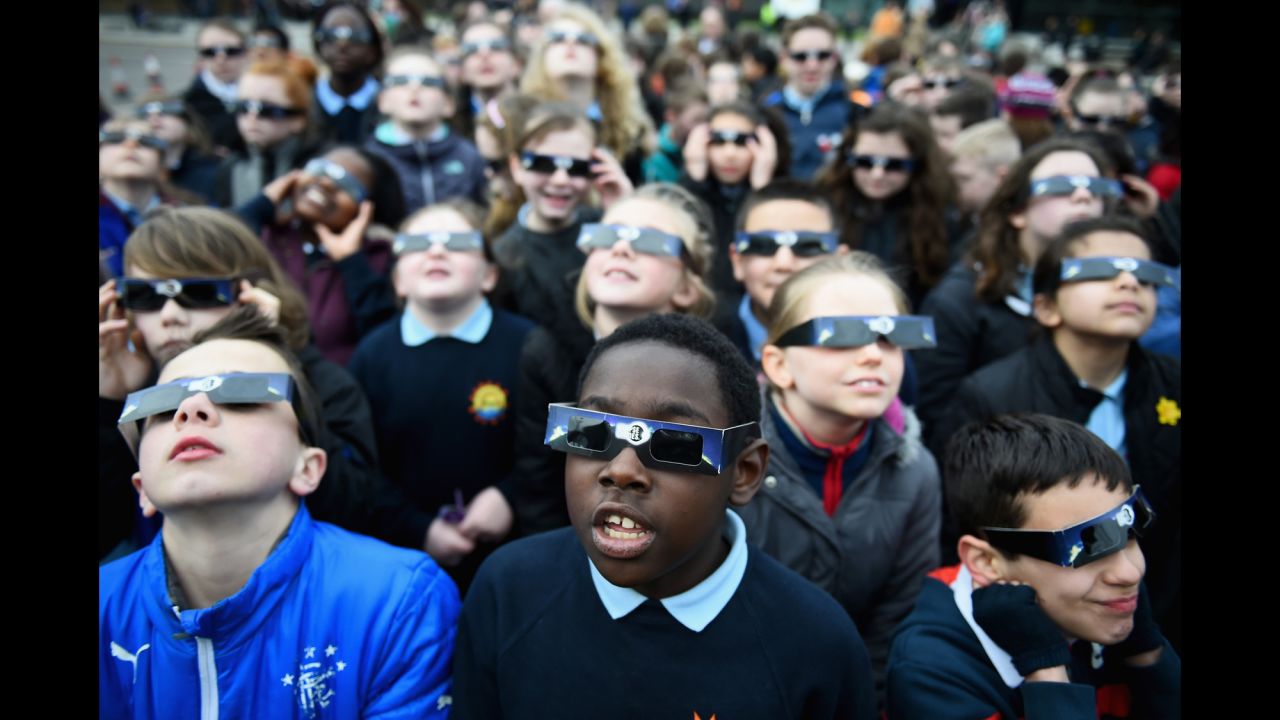 Schoolchildren look into the sky at a partial solar eclipse over Glasgow, Scotland.