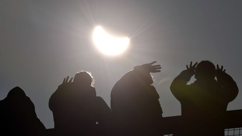 People watch as the solar eclipse begins over Cornwall, England.