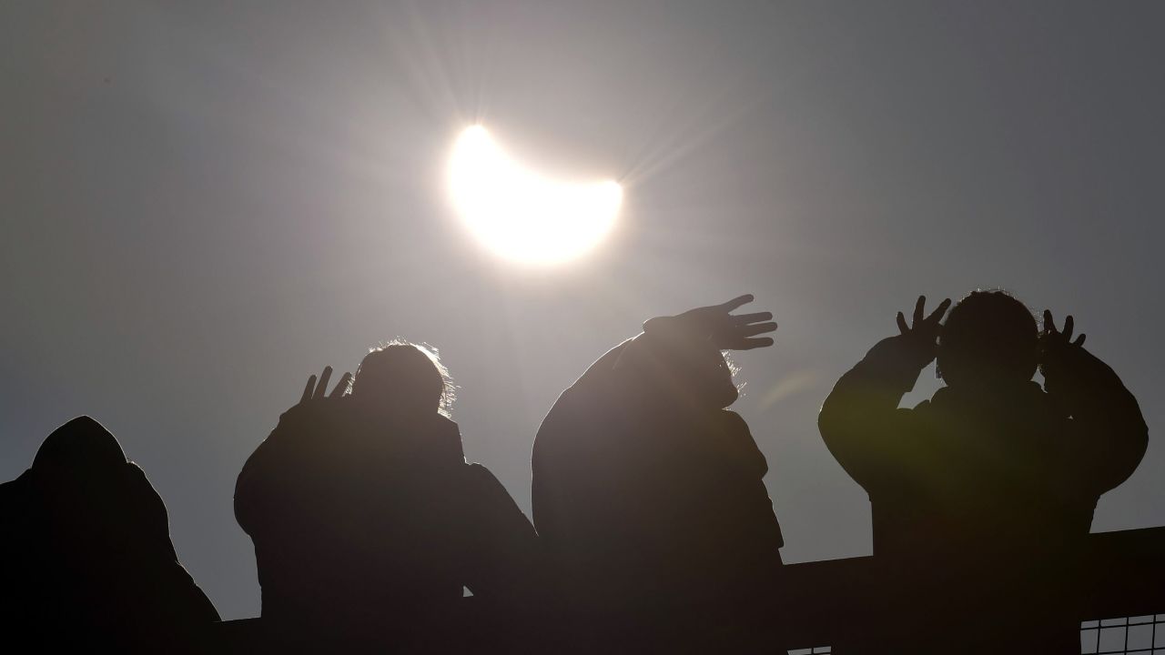 People watch as the solar eclipse begins over Cornwall, England.