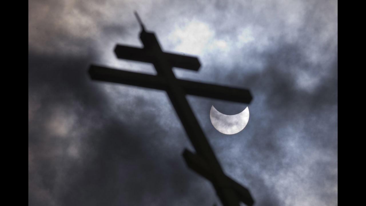 The partial solar eclipse is visible behind a cross on the Church of St. Nicholas in Sofia, Bulgaria.