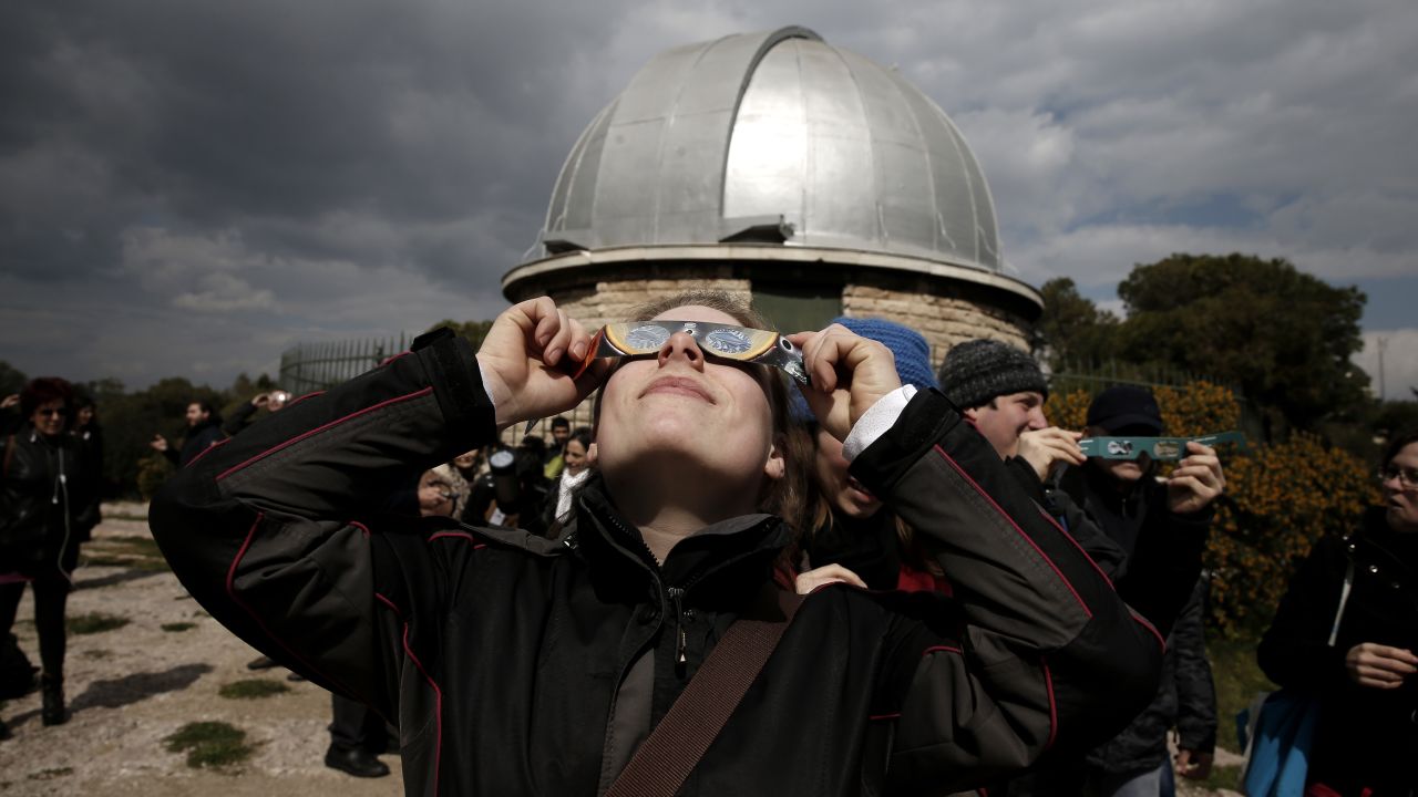A woman looks at the eclipse through special glasses at the National Observatory of Athens in Greece.
