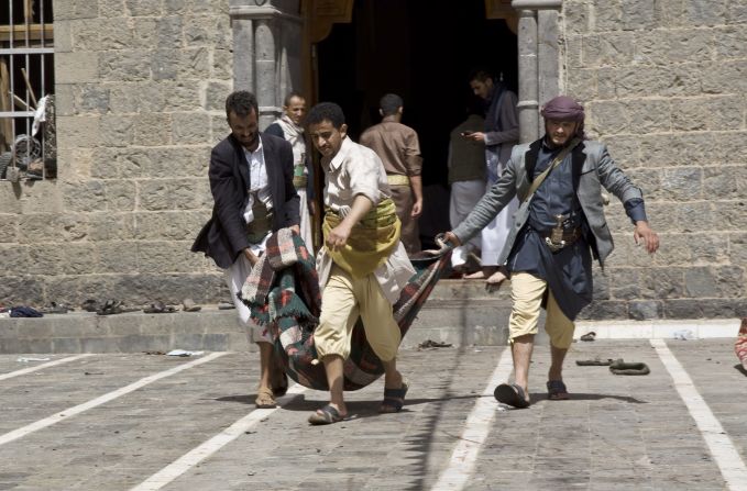 Men carry the body of a man killed in the March 20 attacks.