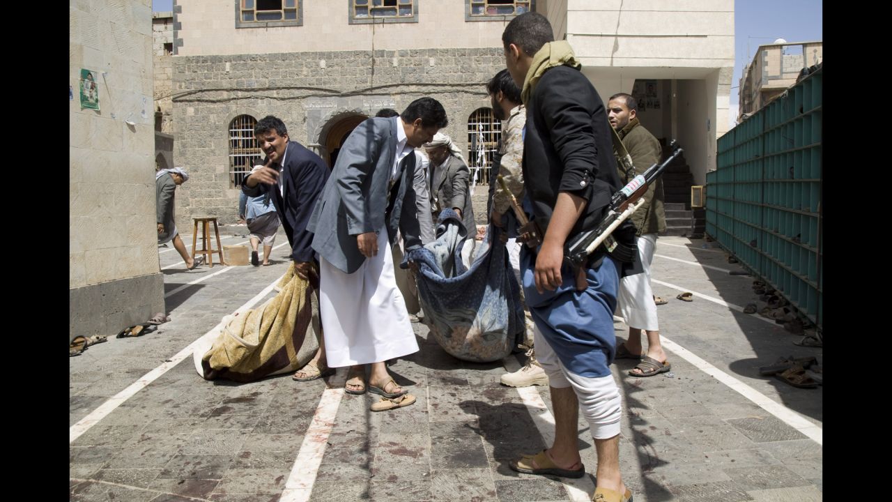 Houthi fighters carry the body of a man killed in Sanaa on March 20.