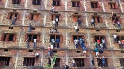 Indians climb the wall of a building to help students in an examination in Hajipur, Bihar, on Wednesday, March 18, 2015.
