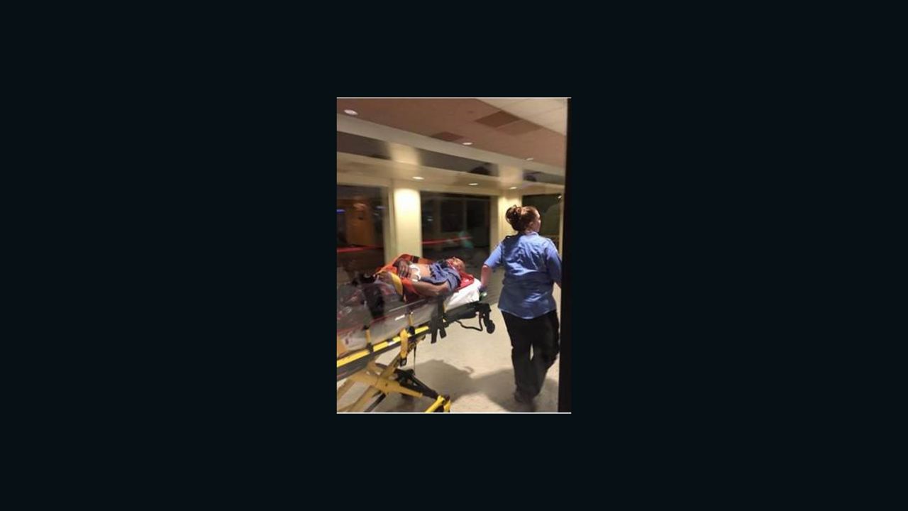 The suspect in the attack on TSA agents at the New Orleans-area airport is taken away on a stretcher.
