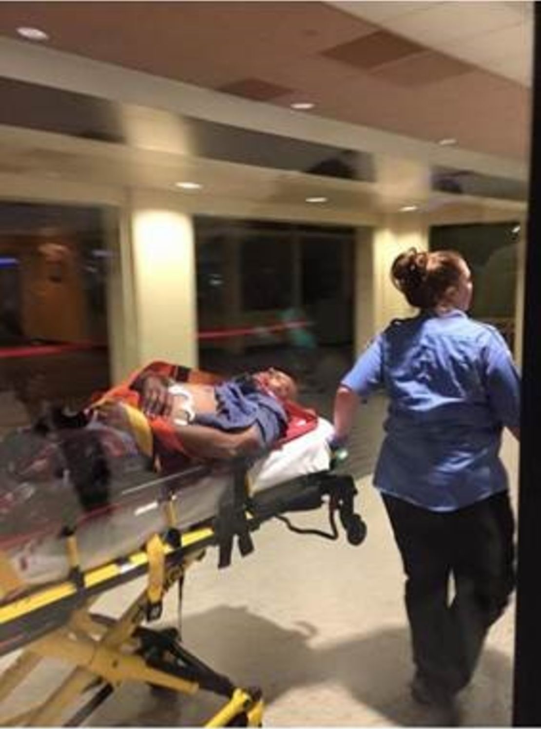 The suspect in the attack on TSA agents at the New Orleans-area airport is taken away on a stretcher.