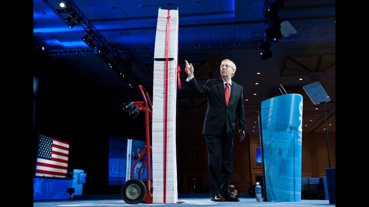 McConnell points to a stack of papers representing what he says are the regulations associated with the Affordable Care Act as he speaks at the 2013 CPAC in National Harbor, Maryland.