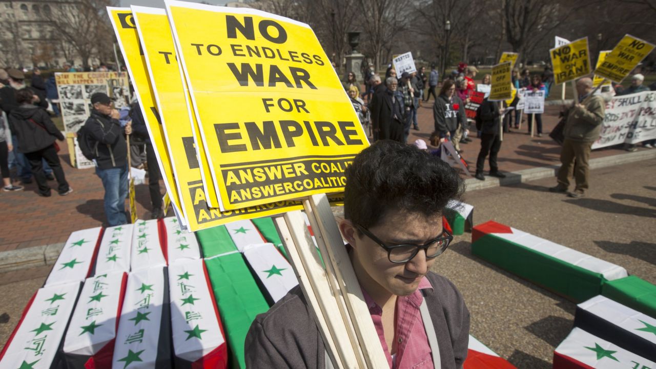 Demonstrators protesting U.S. military involvement overseas carry signs amid mock coffins outside the White House on Saturday.