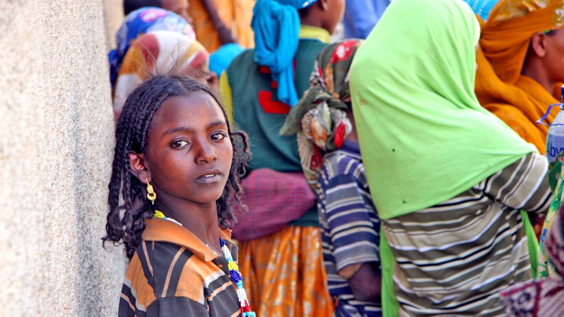 An Oromo girl waits with others who have come to the city to sell firewood carried by their donkeys. 