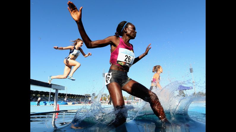 Kenyan runner Magdalene Masai, foreground, splashes into the water during a steeplechase race Saturday, March 21, at the IAAF Melbourne World Challenge. Masai finished second in the 3,000-meter race, which was won by Australia's Madeline Heiner.