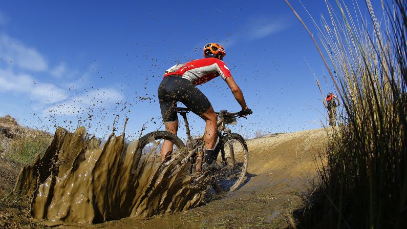 A cyclist splashes through mud Friday, March 20, during the Cape Epic, a mountain bike race held annually on South Africa's Western Cape.