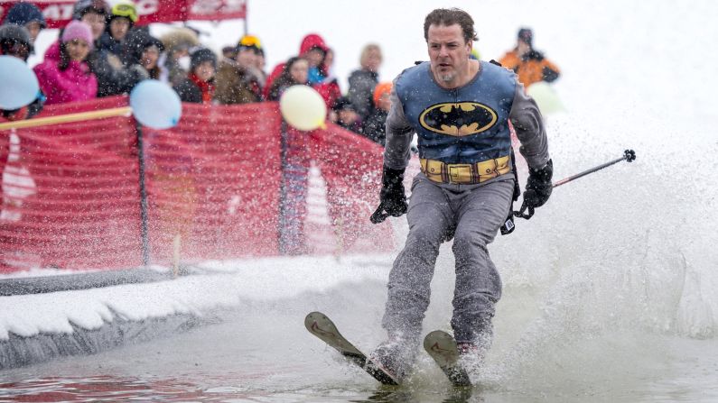A competitor dressed as Batman skims across the water during the Pond Water Skipping event in Cantley, Quebec, on Saturday, March 21.