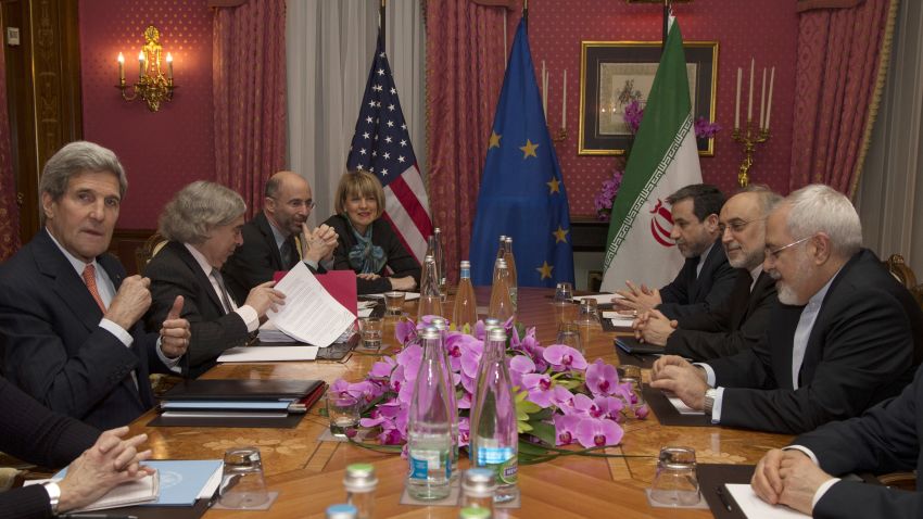 United States Secretary of State John Kerry (L) sits with his delegation during a negotiation meeting concerning Iran's nuclear program with Iran's Foreign Minister Javad Zarif (R) in Lausanne on March 19, 2015 as European Union Political Director Helga Schmid (4-L) looks onover.