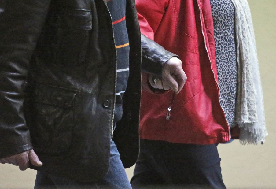 People hold hands walking through the Dusseldorf Airport on March 24.