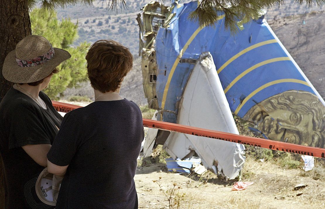 Women look at the debris of the Cypriot Helios airliner which crashed August 13, 2005 at Grammmatiko hills near Athens.
