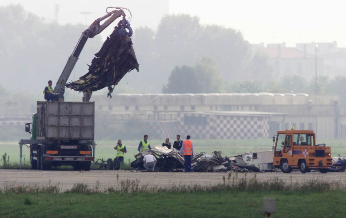 Workers remove wreckage of an MD-87 airliner that crashed at Linate Airport, near Milan, on October 8, 2001.