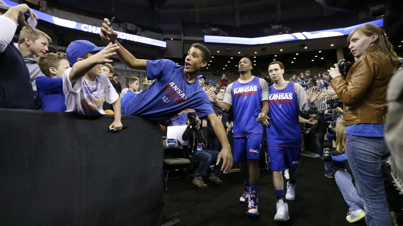 A fan takes a selfie as Kansas basketball players walk to the court for practice Thursday, March 19, in Omaha, Nebraska.
