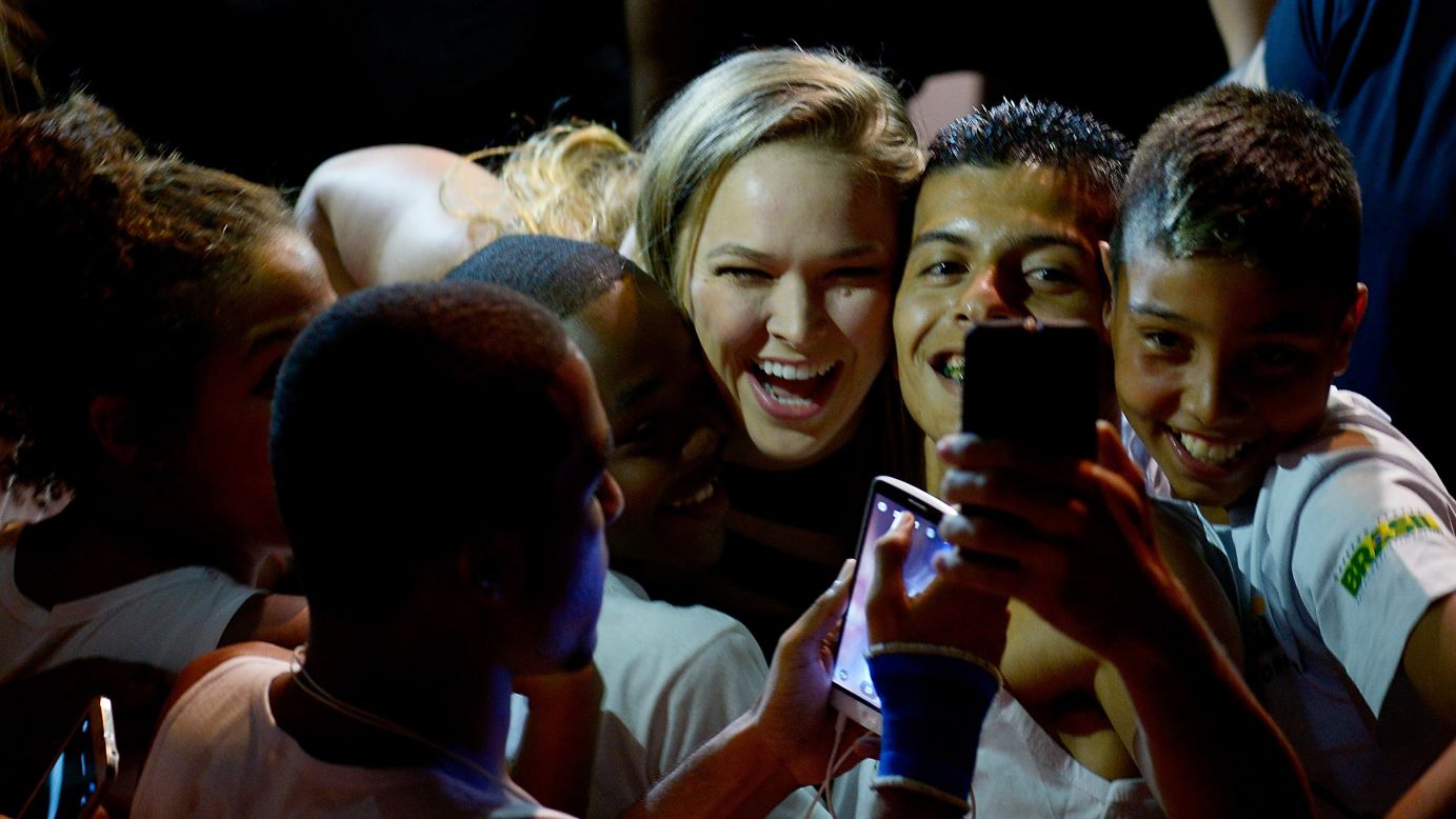 UFC champion Ronda Rousey squeezes between two fans in Rio de Janeiro on Friday, March 20.