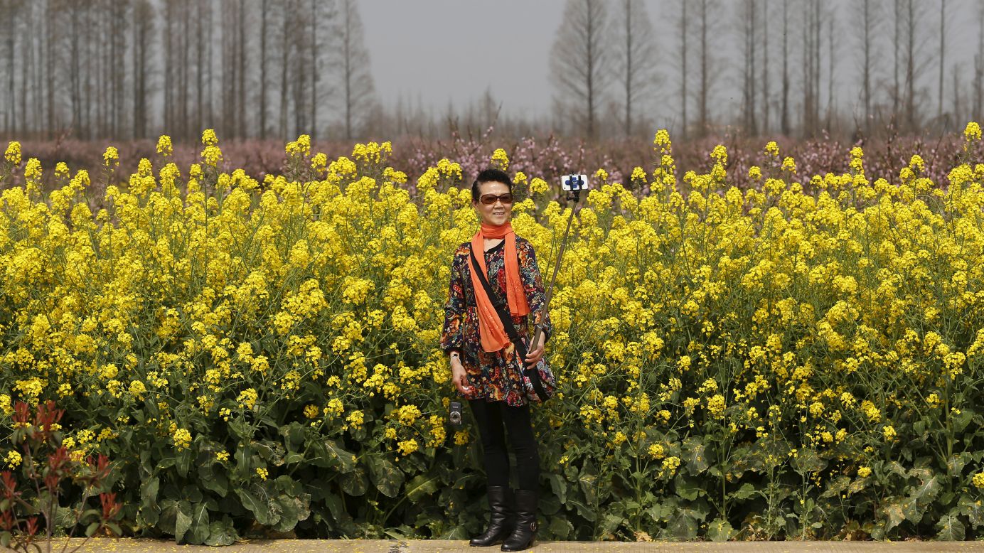 A woman uses a selfie stick on the outskirts of Wuhan, China, on Saturday, March 21.