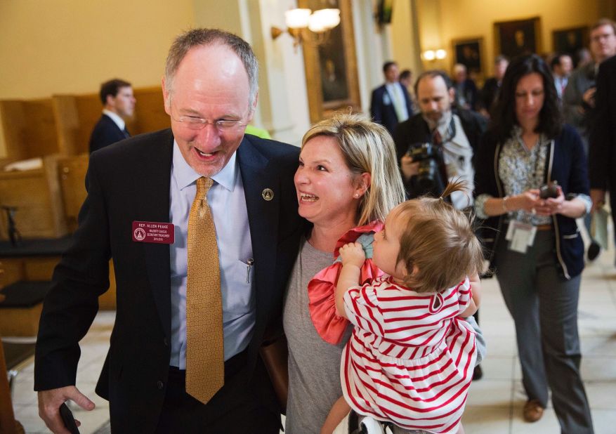 Georgia Rep. Allen Peake celebrates with Kristi Baggarly, holding her daughter Kimber, after the state Senate approved Peake's medical marijuana bill March 24, 2015 in Atlanta. The bill will legalize possession of cannabis oil for treatment of certain medical conditions, such as the seizures suffered by Baggarly's daughter Kendle.