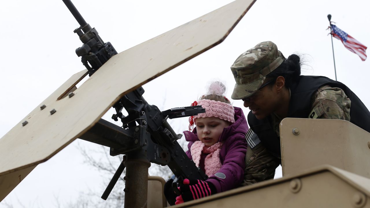 A soldier shows a gun to a young girl in Salociai on March 23.