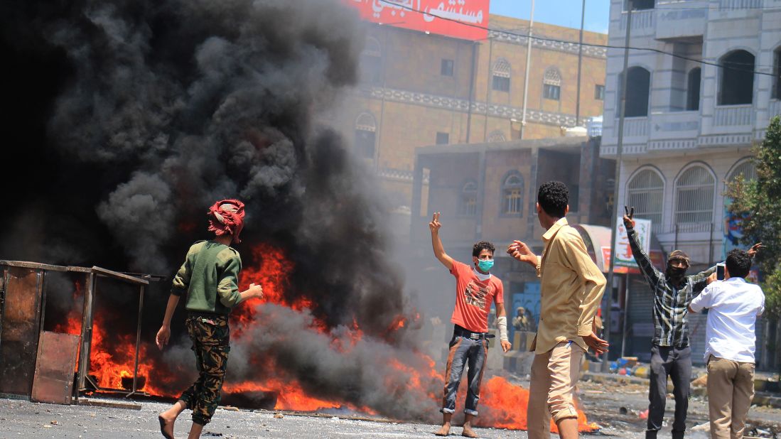 Yemenis stand in front of burning tires during an anti-Houthi protest in Taiz, Yemen, on Tuesday, March 24. 