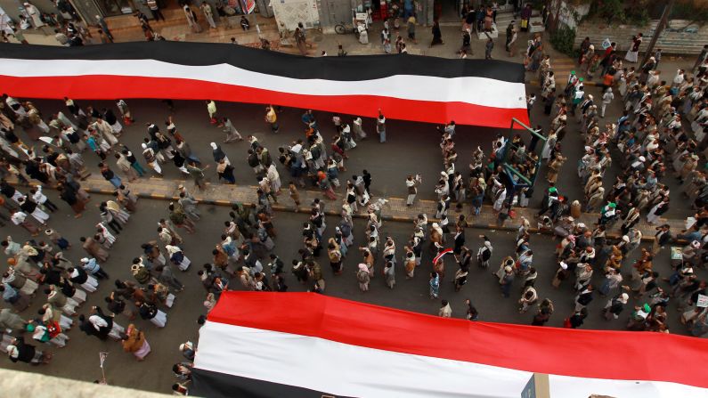 Houthi supporters in Sanaa deploy giant national flags Wednesday, March 18, during a demonstration to mark the fourth anniversary of the "Friday of Dignity" attack. In 2011, forces loyal to Saleh <a href="https://trans.hiragana.jp/ruby/http://www.cnn.com/2011/10/15/world/meast/yemen-unrest/" target="_blank">opened fire on protesters</a> who had gathered in Sanaa to demand the ouster of Saleh and his regime.
