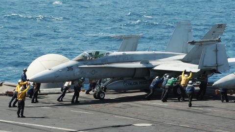 An F/A-18C Hornet is guided on the flight deck of the aircraft carrier USS George H.W. Bush  on August 8, 2014 in the Arabian Gulf. 