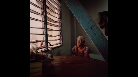 A woman sits by a window in the Casablanca neighborhood of Havana, Cuba. Photographer Carolina Sandretto spent some time in "solares," the crumbling maze-like buildings that many Cubans divide and cohabitate.