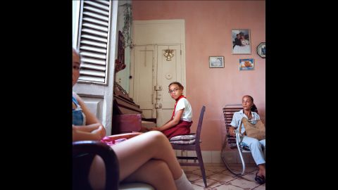 A young girl has a piano lesson in Havana. In solares there are often several generations and separate families sharing one dwelling.