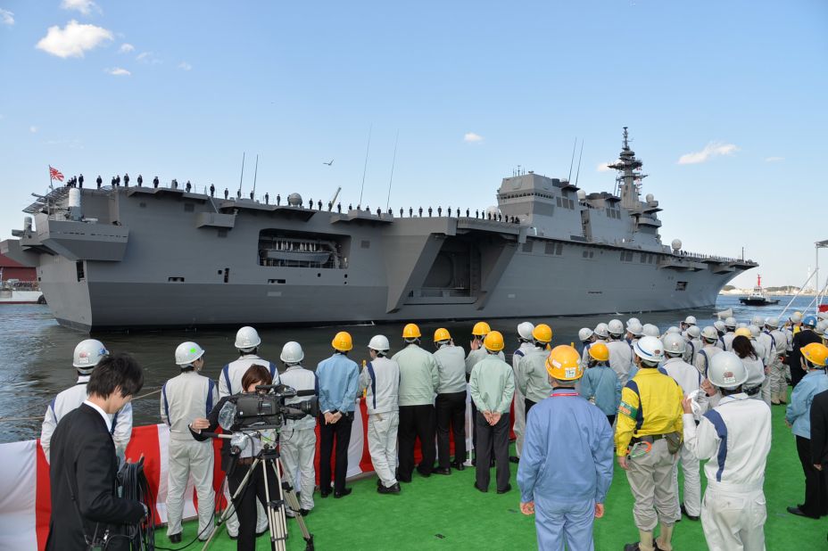Workers look on at Japan's newest -- and biggest -- warship, the Izumo, moored in Yokosuka, Kanagawa prefecture. It's the largest Japanese military vessel since World War II.