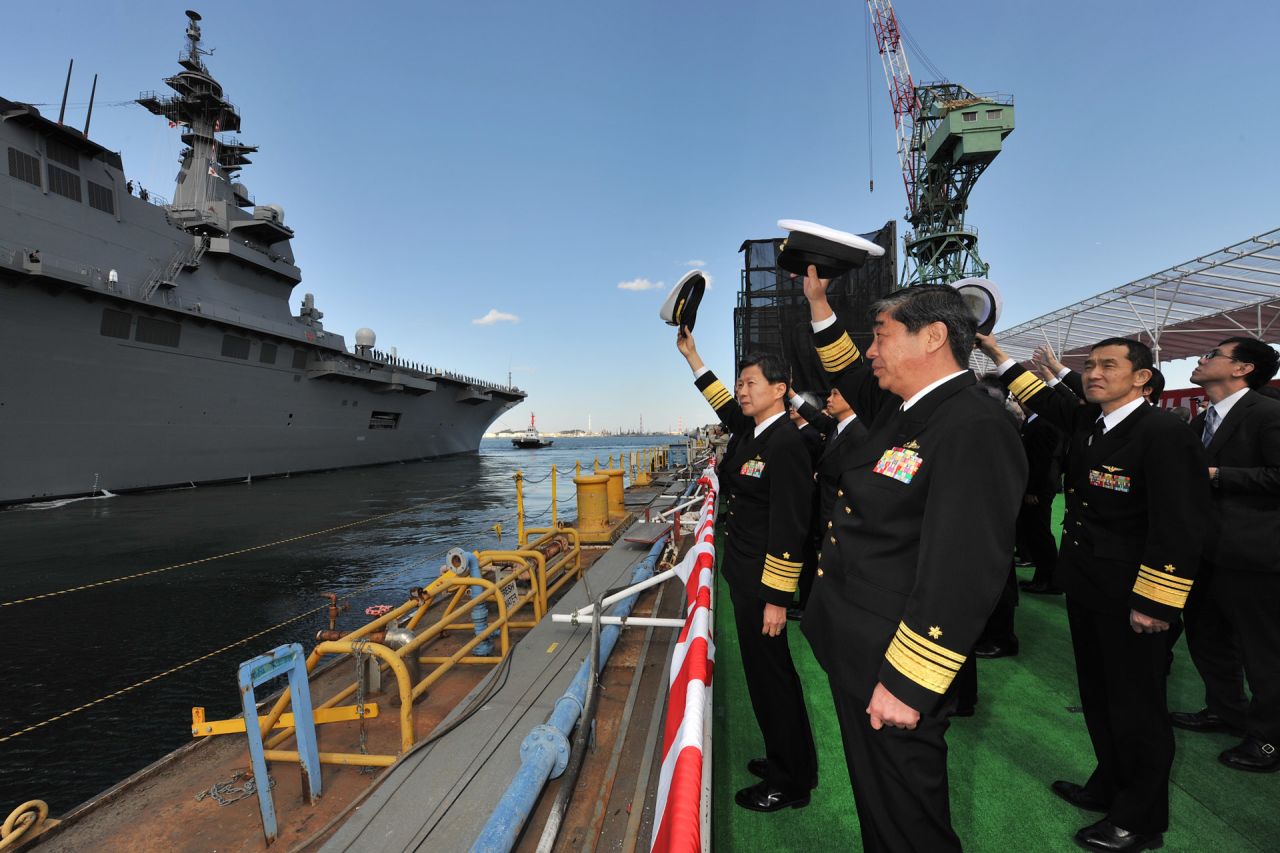 MSDF officials take part in a ceremony marking the commissioning of Japan's new Izumo helicopter carrier.