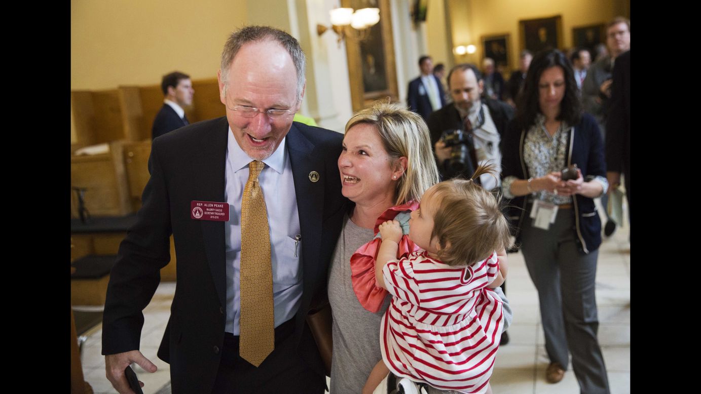Georgia Rep. Allen Peake celebrates with Kristi Baggarly, holding her daughter Kimber, after the state Senate approved Peake's medical marijuana bill Tuesday, March 24, in Atlanta. The bill will legalize possession of cannabis oil for treatment of certain medical conditions, such as the seizures suffered by Baggarly's daughter Kendle.