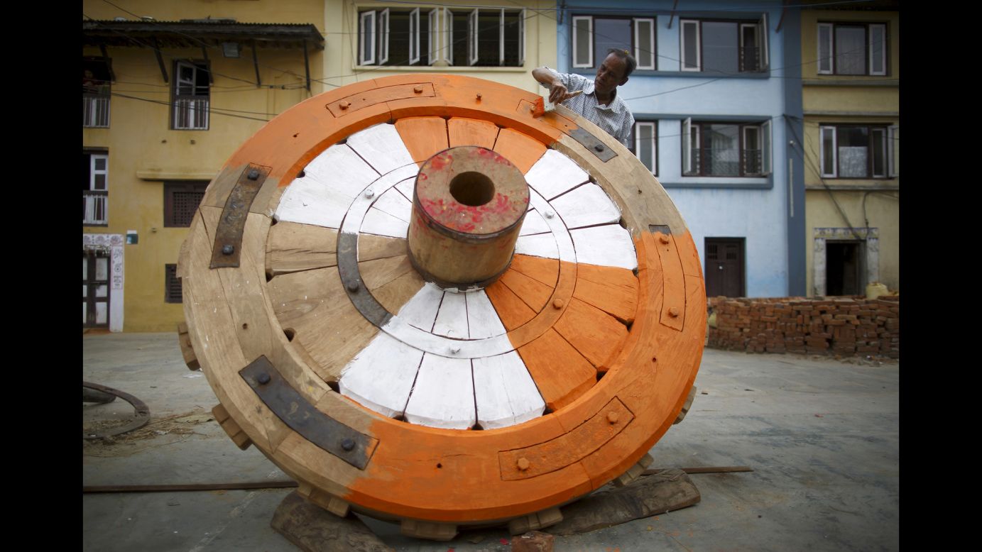 A man paints one of the new wheels for the Rato Machhindranath chariot in Lalitpur, Nepal, on Monday, March 23. The four wheels of the chariot are changed once every 12 years. Both Hindus and Buddhists worship Machhindranath, known as the god of rain, to prevent drought during the rice harvest season.