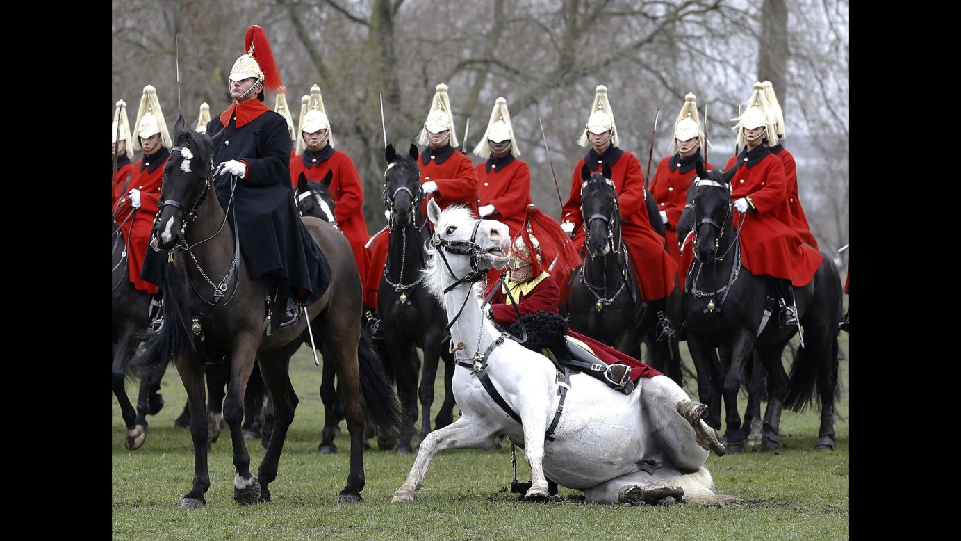 A trumpeter falls off his horse as the Household Cavalry Mounted Regiment parades in London's Hyde Park on Thursday, March 26. The British Army regiment was undergoing its annual inspection.